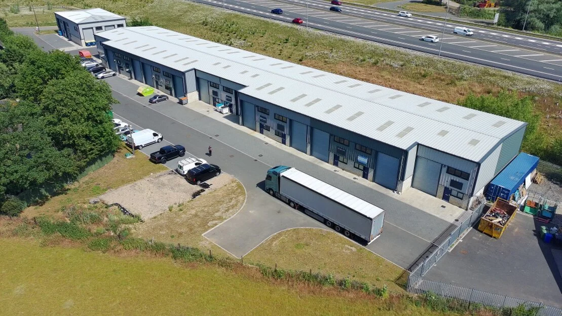 Row of similar industrial units with roller shutter doors